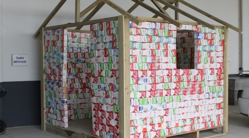 Casinha do Papai Noel com caixas de leite está em construção.
